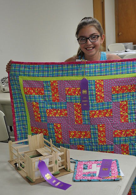 &lt;p&gt;Olivia Clairmont proudly displays her quilt, pot holder and pig in a model projects--all of which received purple ribbons and will be considered for Grand and Reserve Champion awards.&lt;/p&gt;