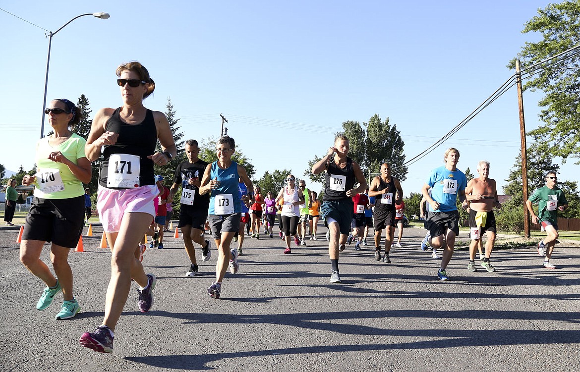 <p>Runners pass the start line at the Mission Mountain 5K and 10K run on Saturday morning.</p>