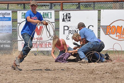 &lt;p&gt;Ty Garrison, Paula Symington, and Taylor Walhood, eventual winners of the calf-dressing contest, put the bloomers on the calf as another contestant zips by looking for a calf to get his rope on.&lt;/p&gt;