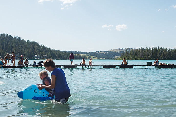 <p>Tré Neether, 13, helps his brother Teagan, 2, onto an inflatable plane Tuesday afternoon at Foy’s Lake, a popular summer destination when the weather is hot.</p>