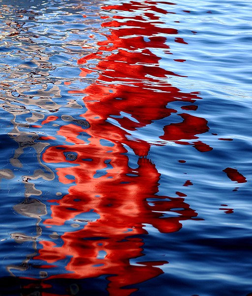 The spinnaker of the Frankly Scarlet casts a strong reflection on the waves of the Flathead Lake on Friday evening.