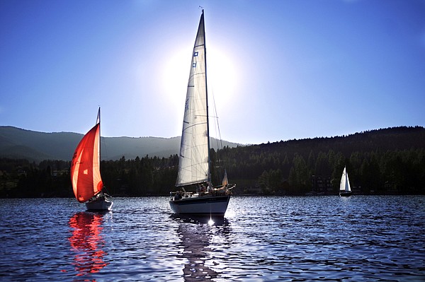 Sailboats are backlit as they wait for the winds to come up on Friday evening on Flathead Lake. The normal Friday night races became a practice run for the Montana Cup Regatta which began on Saturday and continues today.