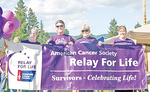 <p>Judy Bloomer, left, Doc Sargent, Paula Darko-Hensler and Rainy Roth hold the survivors banner as they begin the first of many laps around Asa Wood School’s field for Lincoln County’s Relay for Life.</p>