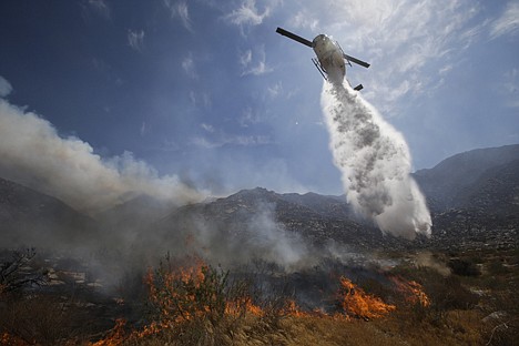 &lt;p&gt;A helicopter drops water over a wildfire on Thursday in Cabazon, Calif.&lt;/p&gt;