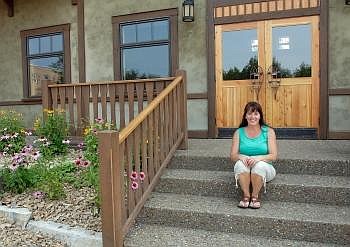 Joan Sandefer, co-owner of the new Cosley Building, poses for a portrait Monday afternoon in front of the building that was remodeled by Glacier DRS in Columbia Falls. Allison Money/Daily Inter Lake