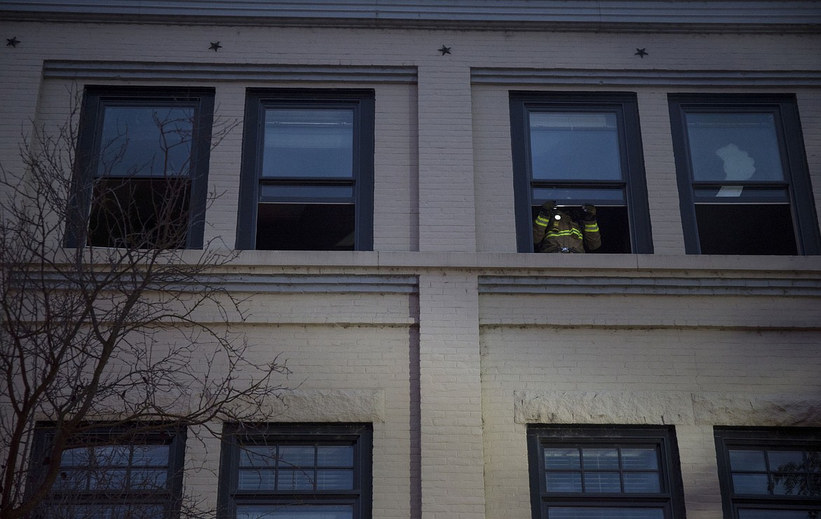 &lt;p&gt;A Coeur d'Alene firefighter raises windows to let smoke escape from a building which caught fire at 325 Sherman Avenue Wednesday night.&lt;/p&gt;