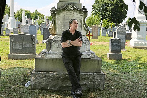 &lt;p&gt;Patric Abedin, who also goes by the name, Nick Beef, poses for a photo Aug. 2 among the grave markers at Calvary Cemetery in the Queens borough of New York. In 1975 Abedin bought the grave plot next to where presidential assassin Lee Harvey Oswald is buried.&lt;/p&gt;