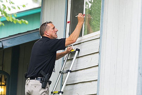 &lt;p&gt;Mark Goodwin, a detective with the Post Falls Police Department, seals the entrances to a home at 502 W. 14th Avenue in Post Falls where a woman was shot Sunday.&lt;/p&gt;