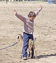 Justin McClure, of Ronan, signals the completion of his run during the goat-tying event at the Southwest Youth Rodeo last Sunday in Ronan.