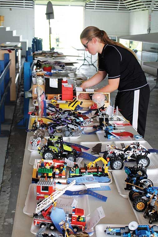 Alexandria Ames checks entries in the youth building at the Grant County Fair during setup Monday. The fair begins its four-day run today.