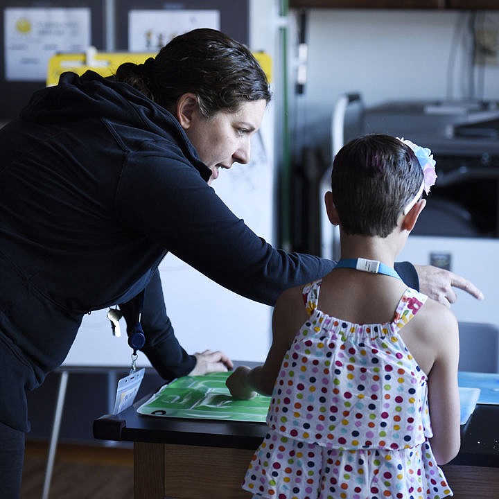 <p>Lori Briggs, program director at Pay It Forward Child & Family Services, Inc., works with Scarlett St. Marie on Thursday, July 28. (Brenda Ahearn/Daily Inter Lake)</p>