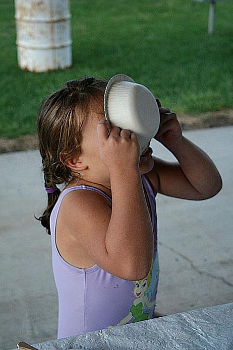 Jason Shueh/Valley Press Bottoms up! Makiya DuBois, age 5, gobbles the last few escaping crumbs in her bowl while letting gravity do the work. After pushing themselves through a flurry of laps and strokes for the Sidekick fundraiser, swimmers flocked to the pie stand for blackberry, apple, peach, and cherry flavoried nourishment.