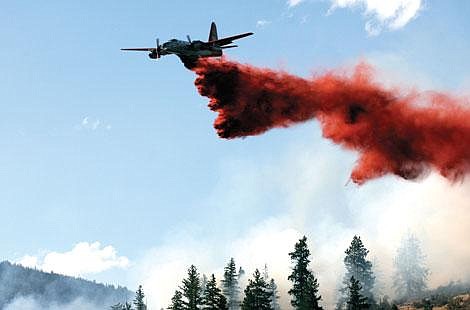 Symona Wood/Sky High Photography A plane drops fire retardant on the Arnold Road fire seven miles west of Plains, the only human-caused fire of the weekend.