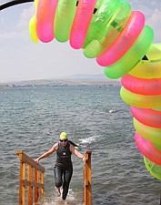 A swimmer leaves the water under the arch during Water Daze last Saturday in Polson.