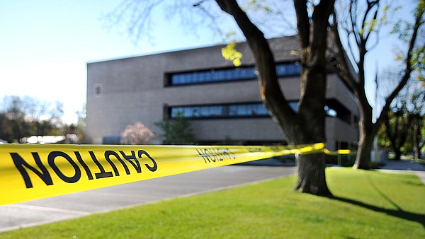 Caution tape surrounds the parking lot of the Earl Bennett Building on Friday morning.