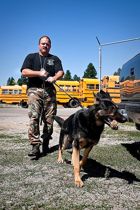 &lt;p&gt;Reward treat in mouth, K-9 patrol dog Koda tugs his handler, Frank Bowne, on the way back to their squad car following a basic training exercise at the Post Falls District bus barn on Friday.&lt;/p&gt;