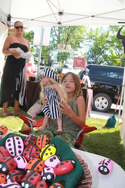 &lt;p&gt;Macy, 7, sits with her very special doll while she sells ladybug rocks at the Aug. 8 art fair.&lt;/p&gt;