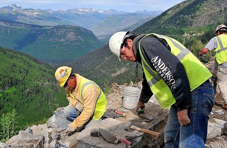 Between Big Bend and Logan Pass on Going-to-the-Sun Road in Glacier National Park, Anderson Masonry employee Mike Bercier chisels stone into shape while co-worker Mike McNally reaches for measuring tape Wednesday morning. Federal stimulus money &#151; $27.6 million from the American Recovery and Reinvestment Act &#151; has helped construction and improvements to continue on the road this summer. The section of road is slated for completion by fall 2011.