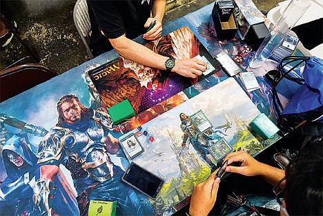 &lt;p&gt;Players take their turns while playing Magic on a game table.&lt;/p&gt;