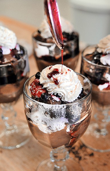 A Huckleberry Brownie Parfait gets a last bit of topping on Friday at Just Deserts in Kalispell. The parfait, made with dark chocolate and light chocolate brownies, Oreo cookie crumbs, hot fudge, chocolate mouse, huckleberry mouse, whipping cream and huckleberries, is one of the deserts Joyce Dye entered in the Huckleberry Days Bake-Off Contest. The parfaits took third in this year's bake-off.