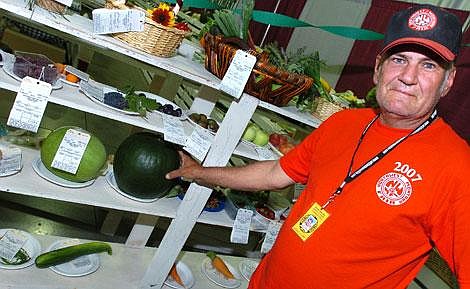 Gary Barge of Kalispell stands near his watermelon entry Wednesday at the Northwest Montana Fair. Barge, a maintenance worker at the fairgrounds, has won blue ribbons as the sole entrant in the watermelon category for the past nine years. Jennifer DeMonte/Daily Inter Lake