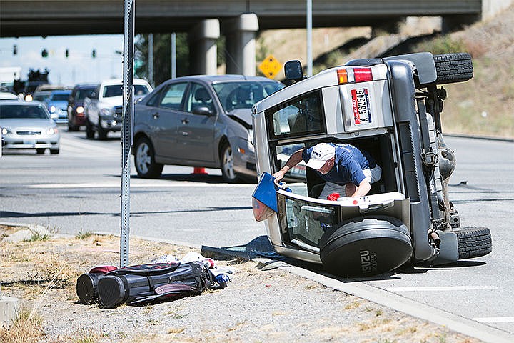 &lt;p&gt;A man clears belongings from an SUV on its side after a two car crash on the intersection of Seltice Way and Ross Point Road Tuesday in Post Falls. The cause of the crash is under investigation.&lt;/p&gt;