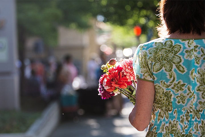 &lt;p&gt;Sally Dodge carries a bouquet of flowers while walking down the Sherman Avenue sidewalk Wednesday during the Farmers&#146; Market.&lt;/p&gt;