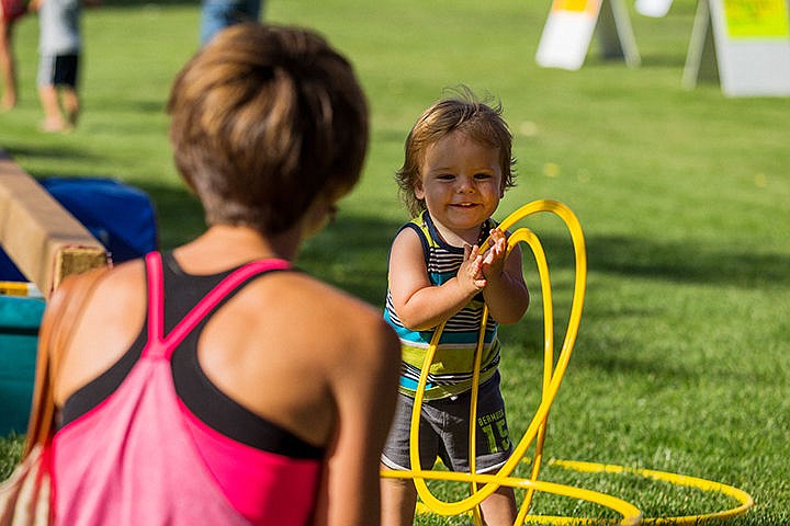 &lt;p&gt;Elijah Ferguson, 1, plays with plastic rings with his mother at the Flip Factory Gymnastics booth.&lt;/p&gt;