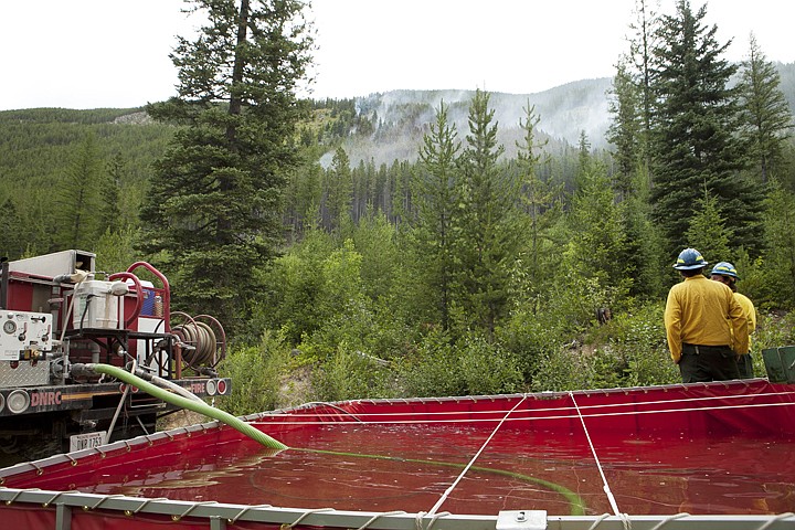 &lt;p&gt;Bryan Olson, left, and Christopher Smith from the Murphy Lake
Ranger Station stand near a portable water tank as they watch the
Fitzsimmons Creek Fire burn Tuesday afternoon east of Stryker.&lt;/p&gt;