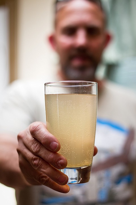 &lt;p&gt;Bruce Mullen, of Post Falls, holds a glass of water that he poured from the tap in his home. The water system in the Arundel By the River mobile home community has been contaminated by river algae for more than a year.&lt;/p&gt;