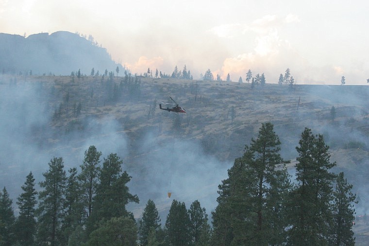 &lt;p&gt;A helicopter carries a load of water across the Perma Bridge Fire Aug. 19.&lt;/p&gt;