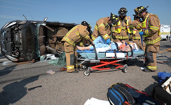 &lt;p&gt;Kalispell firefighters surround the driver of a rollover SUV in the center of Highway 93, at the intersection with Four Mile Drive, on Monday, August 20, in Kalispell.&lt;/p&gt;