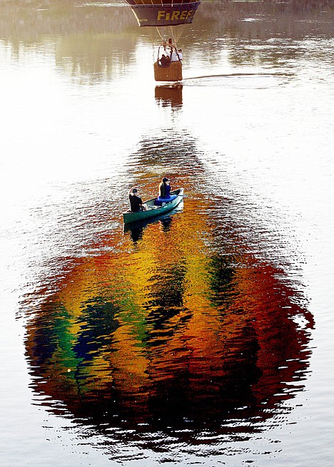 &lt;p&gt;A pilot dips the basket of his hot-air balloon in the Androscoggin River in front of a couple in a canoe during the Great Falls Balloon Festival, Friday in Lewiston, Maine. More than 20 balloons launched at sunrise to kick off the three-day event.&lt;/p&gt;