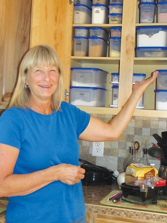 Debi Hill shows off her custom cupboard. She helps customers customize their, helping keep things better organized. They also have a choice of red lids.