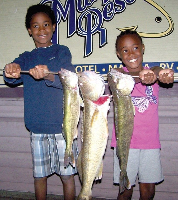 Michael and Sydnee Johnson, of Renton, show off some Walleye as
big as they are, courtesy of Ross Outdoor Adventures.