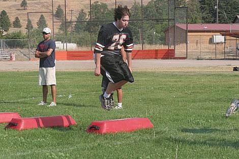 Jamie Doran/Valley Press Conor Ballantyne, a senior offensive lineman and linebacker jumps over practice pads Monday night. Ballantyne is one of seven returning starters that head coach Seth Pettit is really looking towards for leadership.