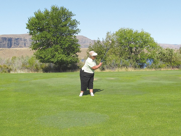 Mavis Bennett keeps her eye on the ball all the way through a
shot on hole No. 6.