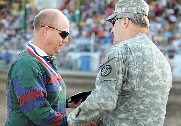 Kevin Kasperson is presented with the Montana National Guard Patriot Medal by Assistant Adjutant Brig. Gen. Stan Putnam on Friday at the Northwest Montana Fair in Kalispell.