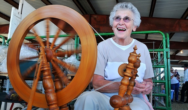 Irene Houston, a founding member of the Alpine Weavers and Spinners Guild, uses her spinning wheel inside the fiber barn at the Northwest Montana Fair on Wednesday afternoon.