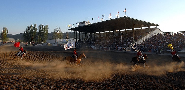 Cowgirls kick up dirt as they ride around the main arena before the start of Thursday night&#146;s rodeo.