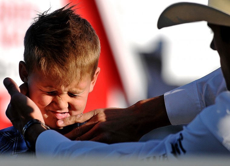 Jace Hill, 5, has dirt wiped off his face by his father Beau Hill after competing in 
mutton-bustin&#146;. Beau Hill, of West Glacier, was competing in the bull riding during the PRCA rodeo on Thursday night.