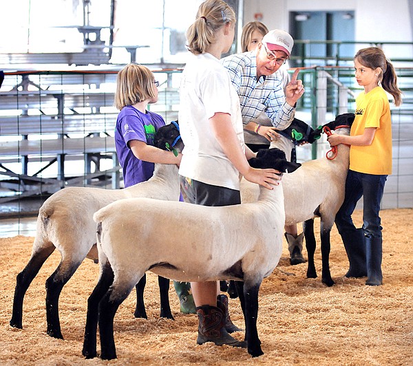 Cortnee Anello, 9, of Columbia Falls, far right, and other members of the Dandy Dudes and Dolls 4-H get tips on their presentation from Anello's grandfather, Paul Atkinson of Columbia Falls on Monday at the Northwest Montana Fair. This is Anello's first year competing, she will be competing with &quot;Simon&quot; in the showmanship and market categories.