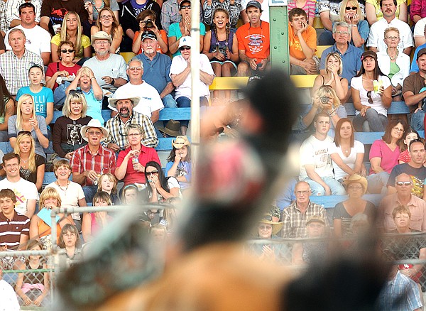 The crowd reacts as Justin Miller of Billings, Mont., competes in the Bareback Riding competition on Friday at the Northwest Montana Fair in Kalispell.