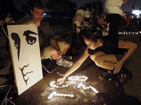 &lt;p&gt;Melanie Curry lights candles at an Elvis Presley display she made on Elvis Presley Boulevard in front of Graceland, Presley's Memphis, Tenn. home, on Aug. 15.&lt;/p&gt;