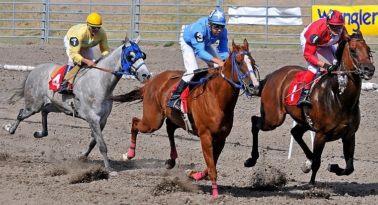 From left, Jeffery Allen Jones on Olympic Spark, Chance Carson on Tanya&#146;s Toad and Bill Christian on Abuse of Power charge down the course in the sixth race Saturday at the Northwest Montana Fair. Abuse of Power held the lead to win the race.