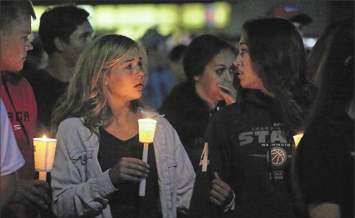 Moses Lake High School Students Ellie Mayo and Alexya Sandmann begin the candlelight walk for Clayton Clark Monday night.