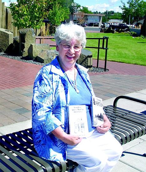 Author Veda Taylor Strong holds up copies of her books, "Grandpa's Adventures" and "Grandma's Snowy Mountain Adventures" while sitting in Sinkiuse Square Tuesday afternoon. Strong returns to Moses Lake Saturday to sign her books at Hastings.