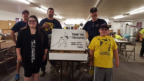 &lt;p&gt;Kiana Johnson-Sharp, center left, and her little brother Quinten Komm, center right, stand with firefighters and a representative of the Bureau of Land Management in a building of the Fruitland fire base camp Sunday after delivering hundreds of cookies, bottles of water and Powerade to the firefighters.&lt;/p&gt;