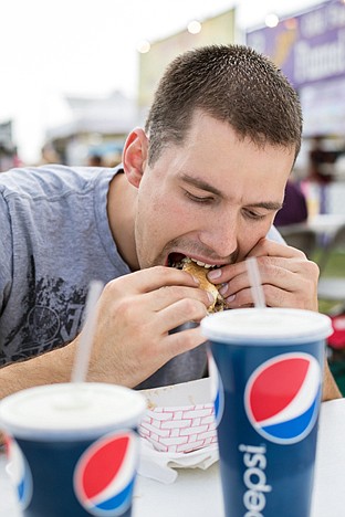 &lt;p&gt;Jerad Storlie takes a bite out of a Philly cheesesteak sandwich Friday at the North Idaho Fair.&lt;/p&gt;