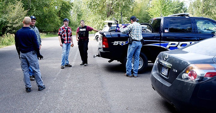 <p><strong>Members of</strong> the Kalispell Police Department return to their vehicles with bicycles, strollers and even a new heat lamp that they hope to return to their rightful owners after clearing out transient camps between Lawrence Park and Whitefish Stage Road on Thursday morning. (Brenda Ahearn/Daily Inter Lake)</p>